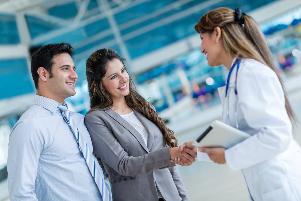 Doctor handshaking with a couple at the hospital Doctor handshaking with a couple at the hospital